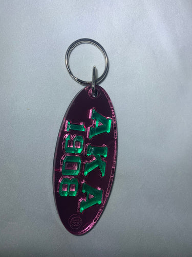AKA 1908 Oval Keychain- Pink Background Green Letters image 0